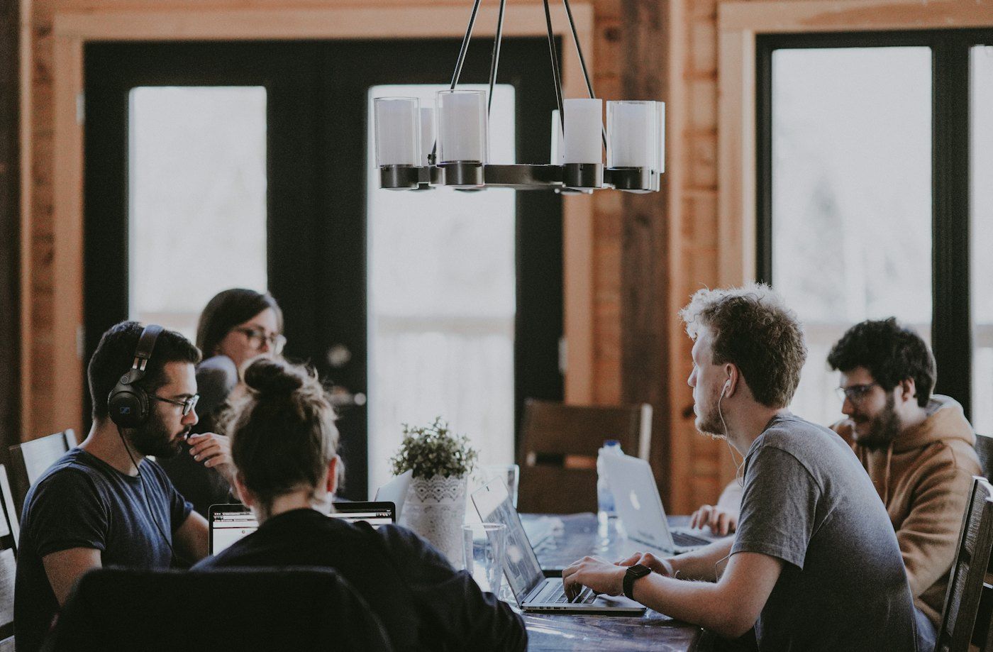 A small team collaborating around a table in a warm, sunlit office