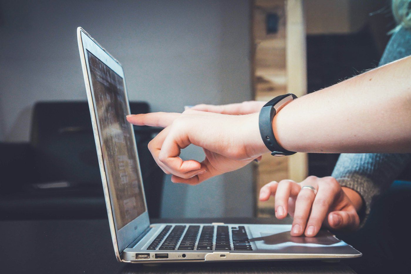 A technician pointing to a laptop screen while walking someone through a new setup